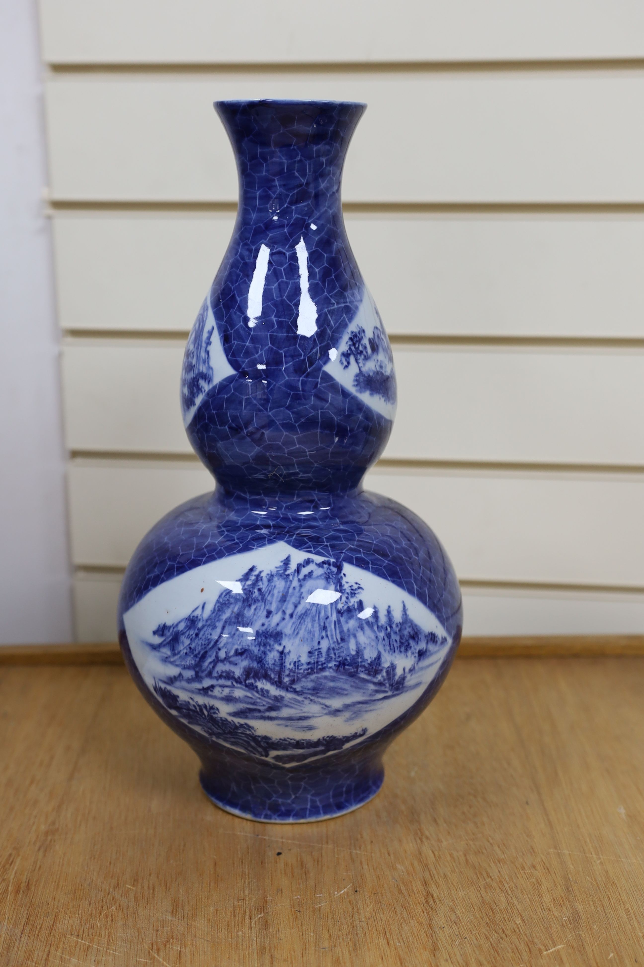 A Chinese blue and white gourd vase with landscape decoration, a similar blue and white sleeve vase and a Japanese Kutani vase